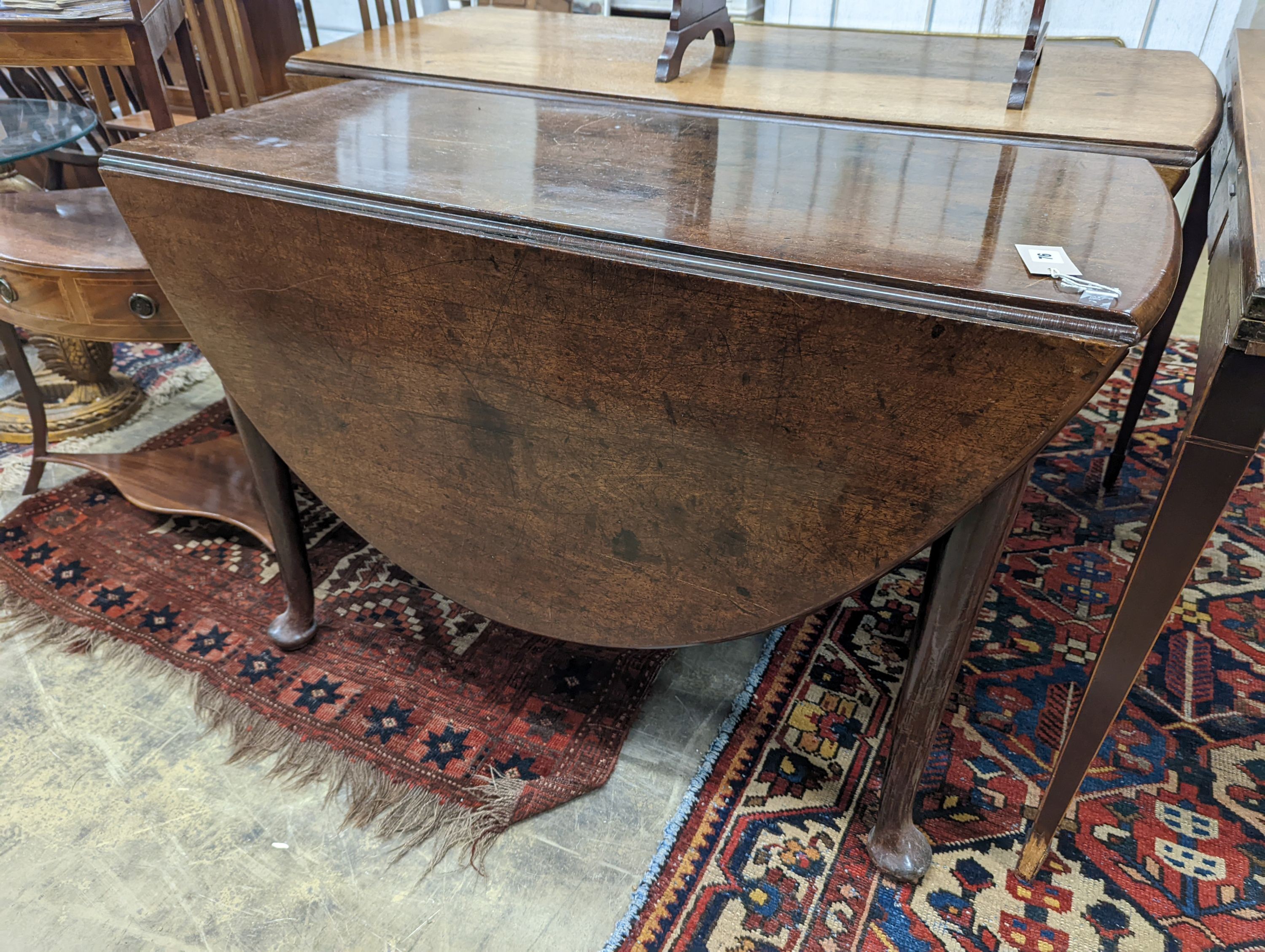 A George III oval mahogany drop leaf pad foot dining table, width 108cm, length 134cm extended, height 70cm